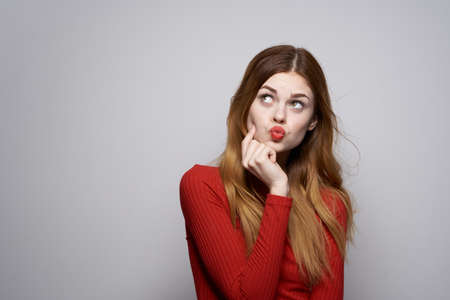 pretty woman in red dress posing luxury hand gesture isolated backgroundの写真素材