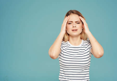 woman with angry expression in striped t-shirt tin plate with hands blue backgroundの写真素材