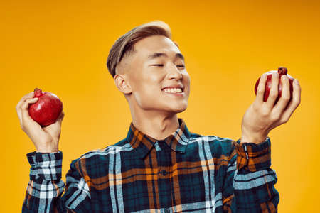 a man of asian appearance and a plaid shirt grenade in his handsの写真素材