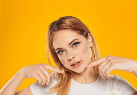 cheerful woman in a white t-shirt hand gesture Studio Model close-upの写真素材