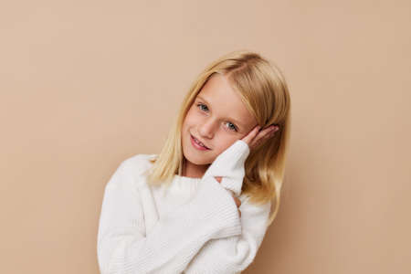 Beautiful little girl gestures with his hands posing studioの写真素材