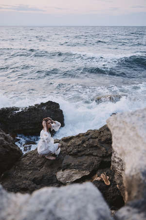 Woman in white dress rocks nature landscape ocean travelの写真素材