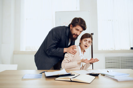 business man and woman sitting at the table working office officialsの写真素材