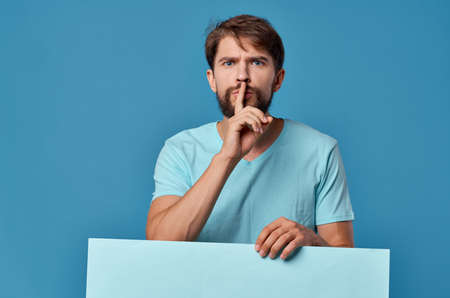 Cheerful man blue paper in the hands of marketing fun Lifestyle isolated backgroundの写真素材