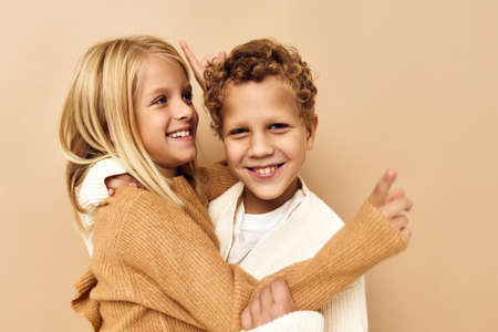 little children hugs laughter friendship beige backgroundの写真素材