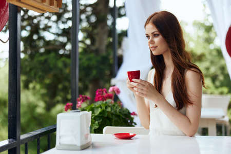 Portrait of young beautiful woman sitting in an outdoor cafe breakfast Summer dayの写真素材