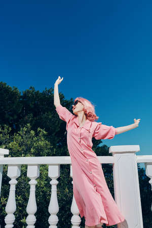 attractive woman with pink hair wearing sunglasses posing Relaxation conceptの写真素材
