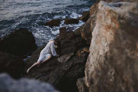 Barefoot woman in white wedding dress on sea shore wet hair natureの写真素材