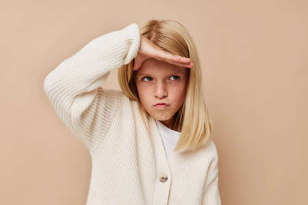 happy cute girl fashionable baby clothes on a beige backgroundの写真素材