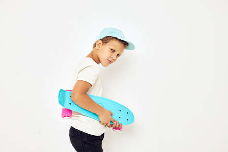 Portrait of young smiling kid skateboard in hands posing isolated backgroundの写真素材