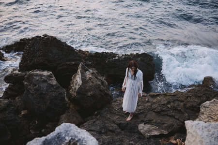Woman in white dress rocks ocean nature travelの写真素材