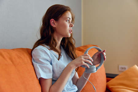 smiling woman headphone at home on the couch entertainment unalteredの写真素材