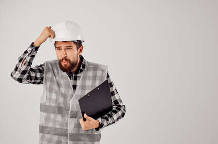 male worker in a white helmet blueprints Professional light background