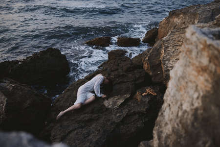 woman in white wedding dress on sea shore wet hair view from aboveの写真素材