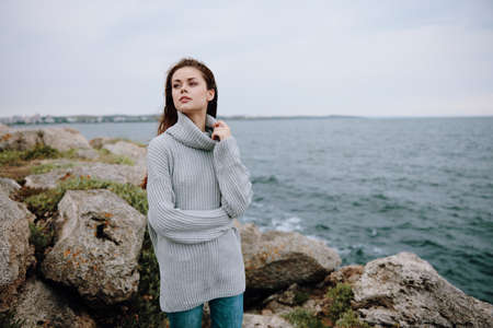 woman sweaters cloudy sea admiring nature Relaxation conceptの写真素材