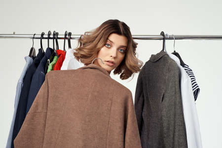 emotional woman in red dress Shopaholic choosing clothes shopping in store light background