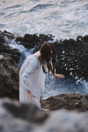 Woman in white dress rocks sea natureの写真素材