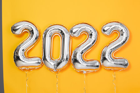 Foil balloons numeral 2022 New year 2022 celebration Decorative design elements yellow backgroundの写真素材