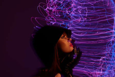 Pretty young female neon lines posing model glamor color background unalteredの写真素材
