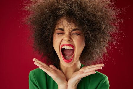 Pretty young female grimace afro hairstyle red lips fashion color background unalteredの写真素材