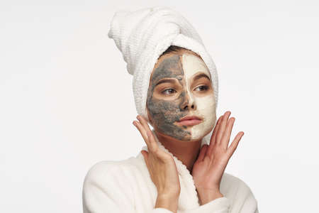 woman with towel on head mask on face clean skin light backgroundの写真素材