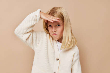 Beautiful little girl in a sweater, grimaces kids lifestyle conceptの写真素材