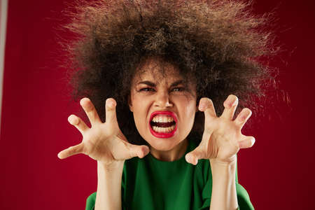 Beautiful fashionable girl with curly hair grimace posing emotion studio model unalteredの写真素材