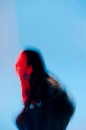beautiful woman Glamor posing red light metal armor on hand blue background