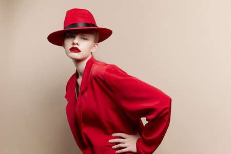 pretty woman red jacket and hat red lips fashion studio model unalteredの写真素材