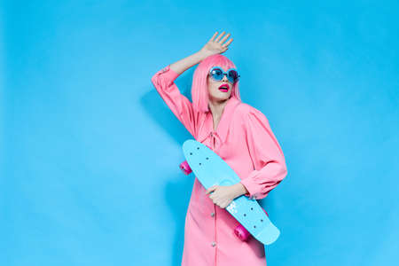 glamorous woman fashion blue glasses skateboard isolated backgroundの写真素材