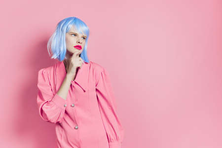 glamorous woman in blue wig pink dress red lips pink backgroundの写真素材
