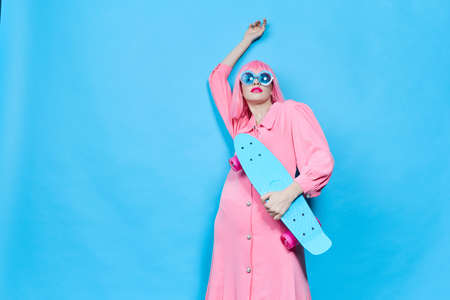 fashionable woman in sunglasses wears a pink wig isolated background