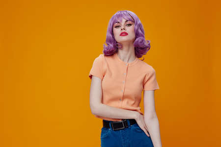 Positive young woman purple hair fashion posing glamor yellow background unalteredの写真素材