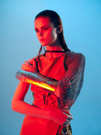 photo pretty woman Glamor posing red light metal armor on hand Lifestyle unaltered