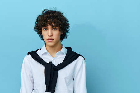 curly guy in a white shirt sweater on the shoulders cropped view