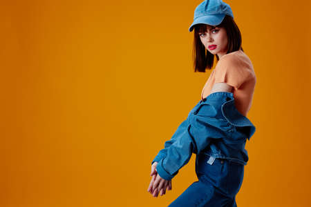 pretty woman stylish denim clothing posing yellow background unaltered