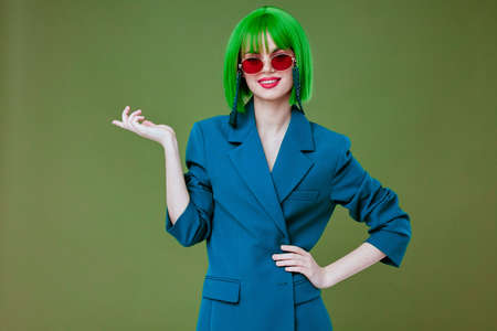 cheerful young woman in green wig fashion posingの写真素材