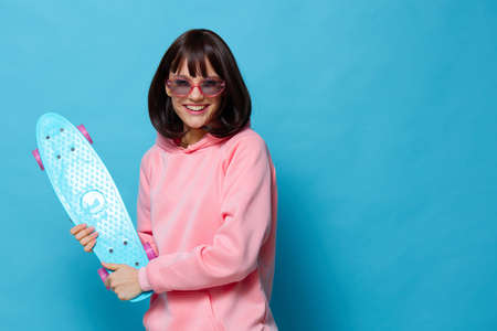 woman in a pink sweater skateboard entertainment blue background