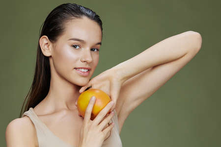 young woman grapefruit in hands posing clean skin isolated backgroundの写真素材