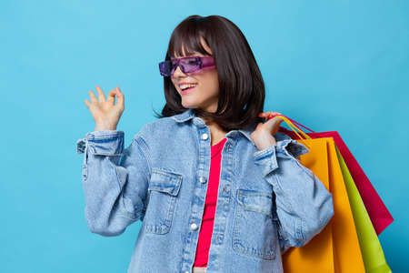 young woman shopping in the store fun entertainment blue background