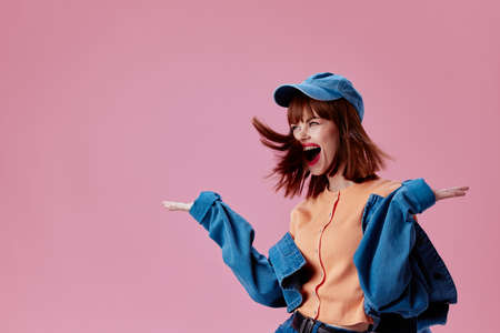 Positive young woman denim cap red lips glamor fashion pink background unalteredの写真素材