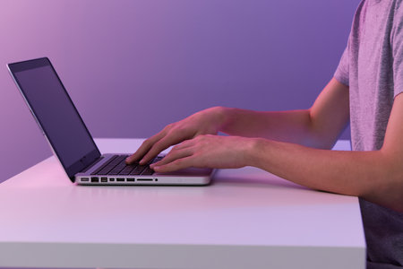 gamer cyberspace playing with in front of a laptop violet background