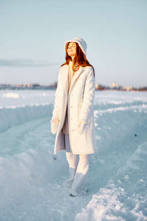 young woman in a white coat in a hat winter landscape walk travelの写真素材