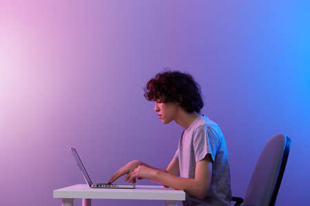 gamer cyberspace playing with in front of a laptop violet background