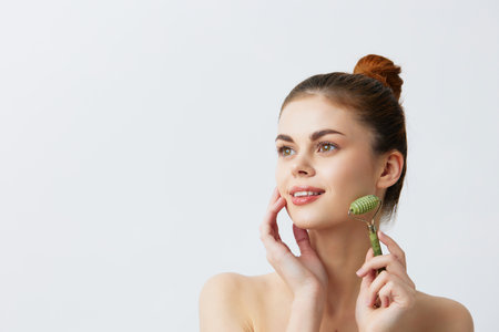 pretty woman jade face massager wrinkle smoothing close-up Lifestyleの写真素材