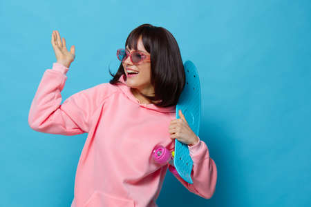 young woman blue skateboard posing fun Lifestyle fashionの写真素材