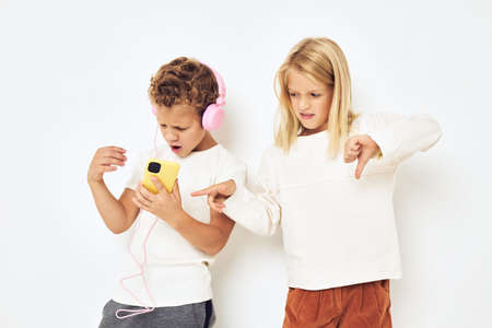 Image of boy and girl headphones with phone entertainment light backgroundの写真素材