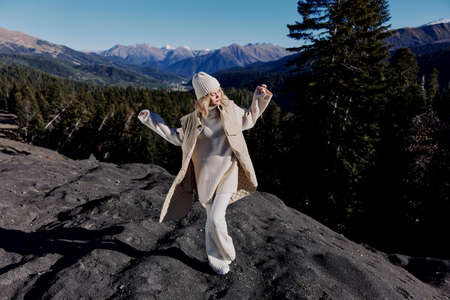 tourist in autumn clothes stands on a rock landscape blue sky lifestyle