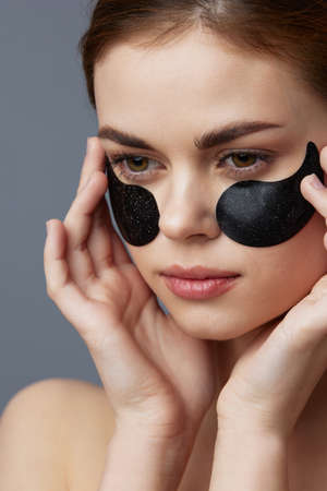 woman with patches on the face clean skin health rejuvenation Gray backgroundの写真素材