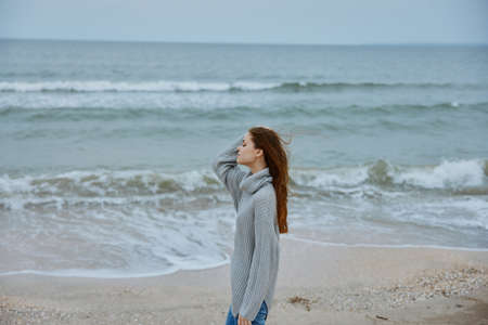 beautiful woman alone by the ocean cloudy weather unalteredの写真素材